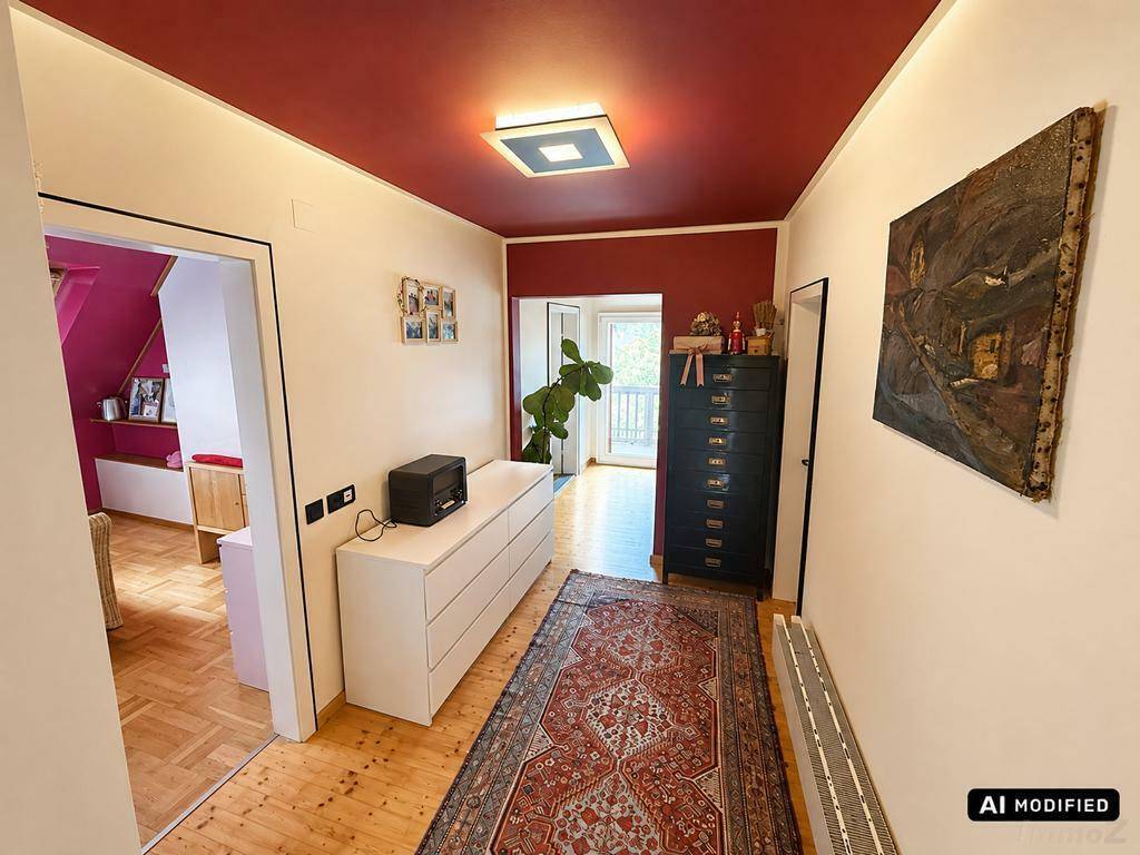 Langer Flur mit roter Decke, Holzboden und einem Teppich in warmen Farben.