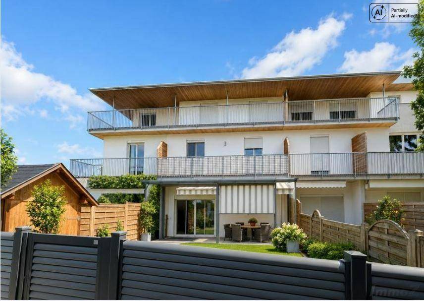 Moderne Wohnanlage mit weißer Fassade, Balkonen und gepflegtem Gartenbereich.