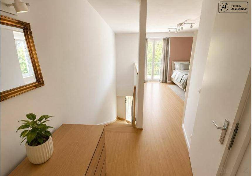 Heller Flur im Obergeschoss mit Holzfußboden und Blick in ein Schlafzimmer.