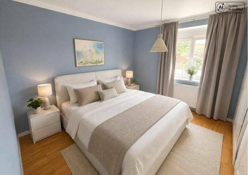 Gemütliches Schlafzimmer mit blauen Wänden, Holzboden und großem Doppelbett.