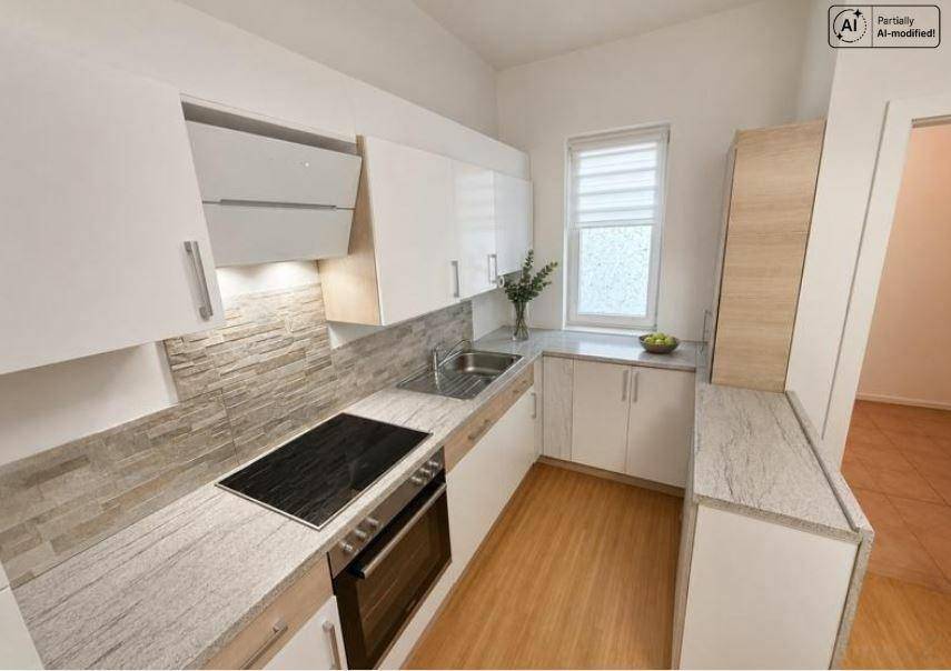 Moderne Einbauküche mit hellen Fronten, Granitarbeitsplatte und integrierten Geräten.