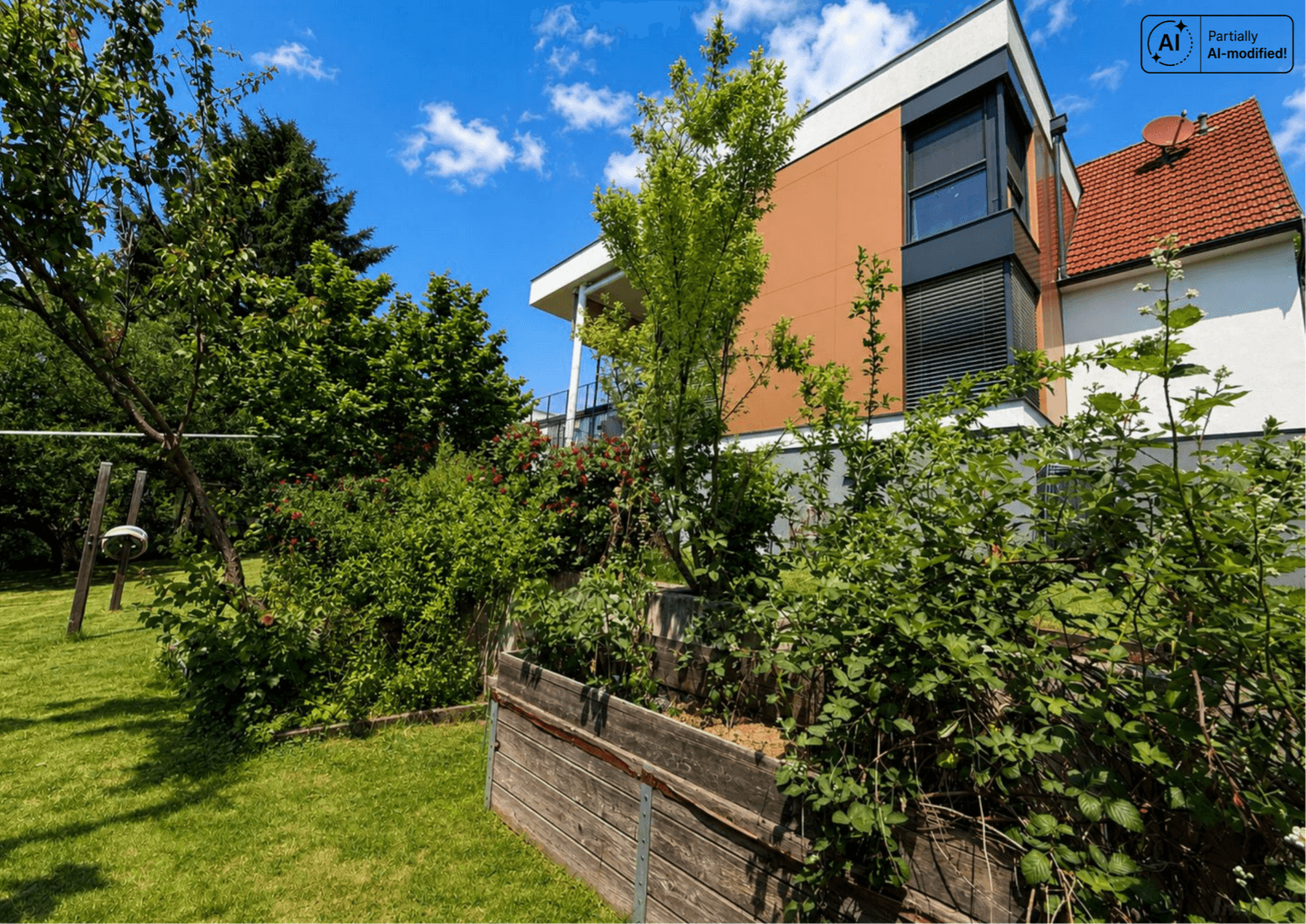 Gepflegter Gartenbereich mit Hochbeet und Rasenfläche neben dem modernen Wohngebäude.