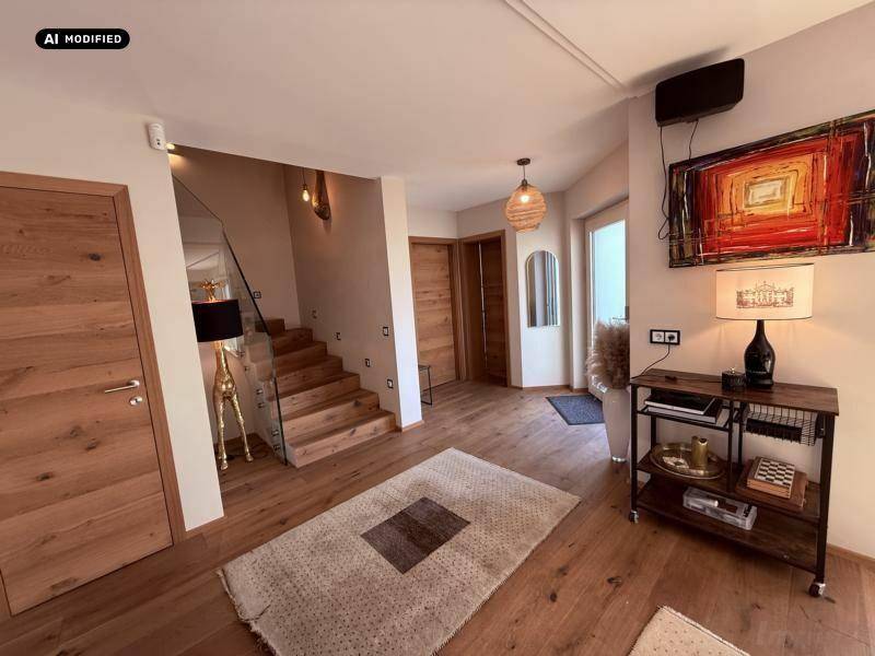 Heller Eingangsbereich mit Holzboden, moderner Treppe und dekorativen Elementen.