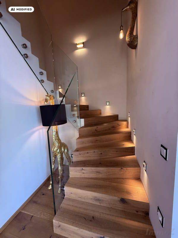 Elegante Holztreppe mit Glasgeländer und integrierter Wandbeleuchtung.