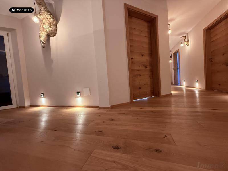 Langer Flur mit Holzboden, Holztüren und integrierter Bodenbeleuchtung.