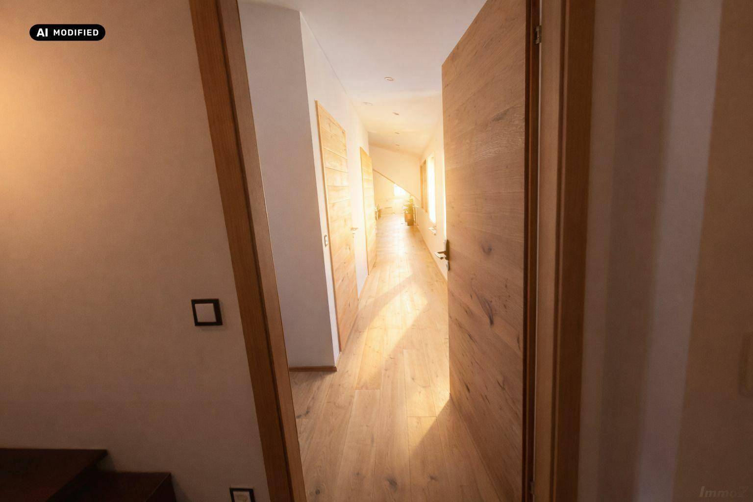 Heller Flur mit Holzboden und Holztüren, der zu weiteren Räumen führt.