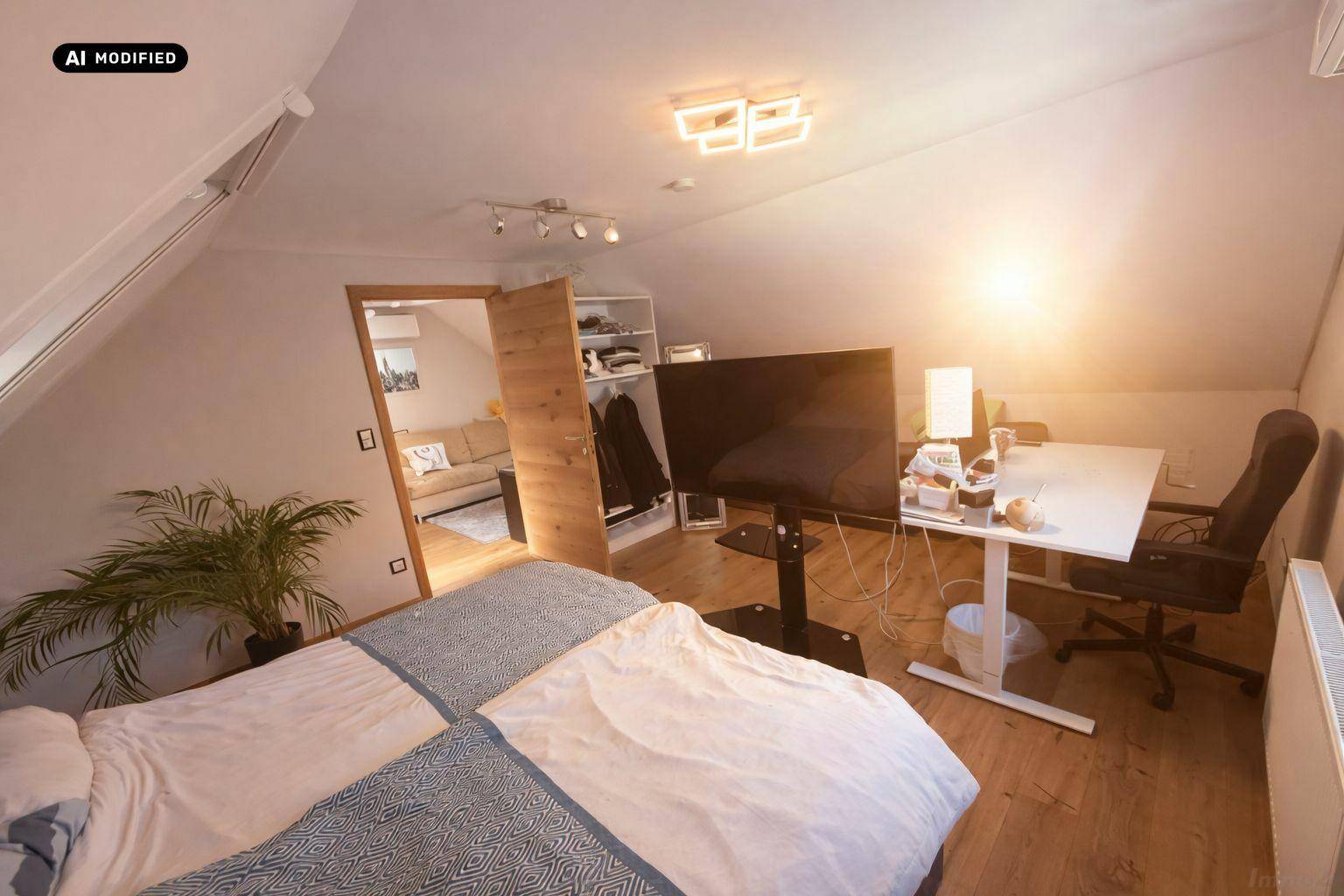 Helles Schlafzimmer mit Holzboden, Dachschräge und Zugang zu einem weiteren Raum.