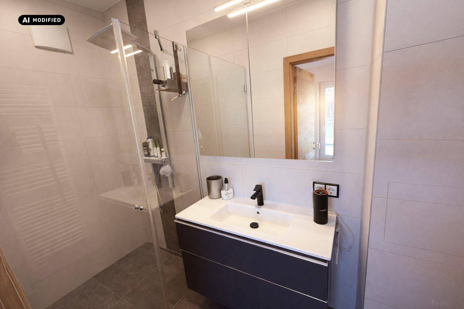 Modernes Badezimmer mit ebenerdiger Dusche, Waschtisch und großem Spiegel.