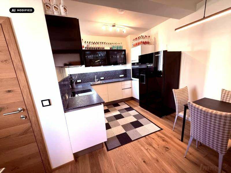 Moderne Küche mit Essbereich, weißen Schränken und dunkler Arbeitsplatte.