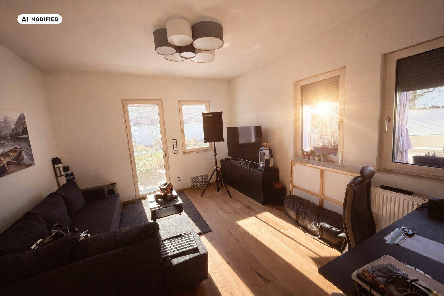 Helles Wohnzimmer mit Holzboden, Sofa und Zugang zum Außenbereich.