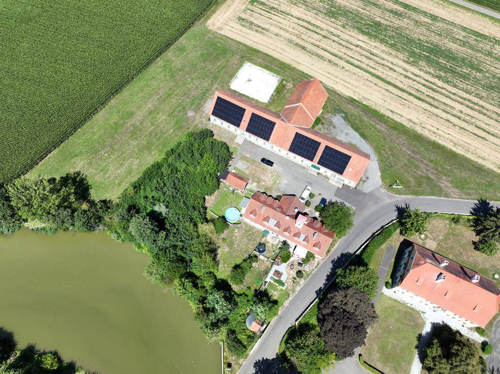Luftaufnahme des Anwesens mit Hauptgebäude, Nebengebäuden, Pool und Photovoltaikanlage.