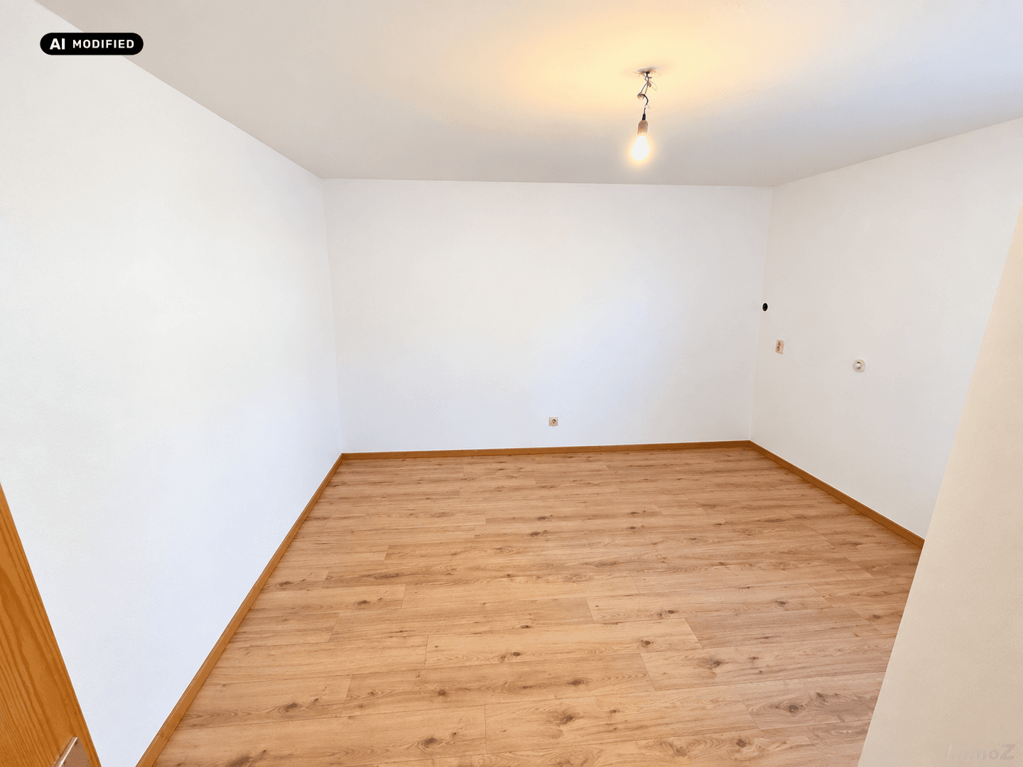 Leerer Raum mit hellem Holzboden und weißen Wänden, bereit für individuelle Gestaltung.
