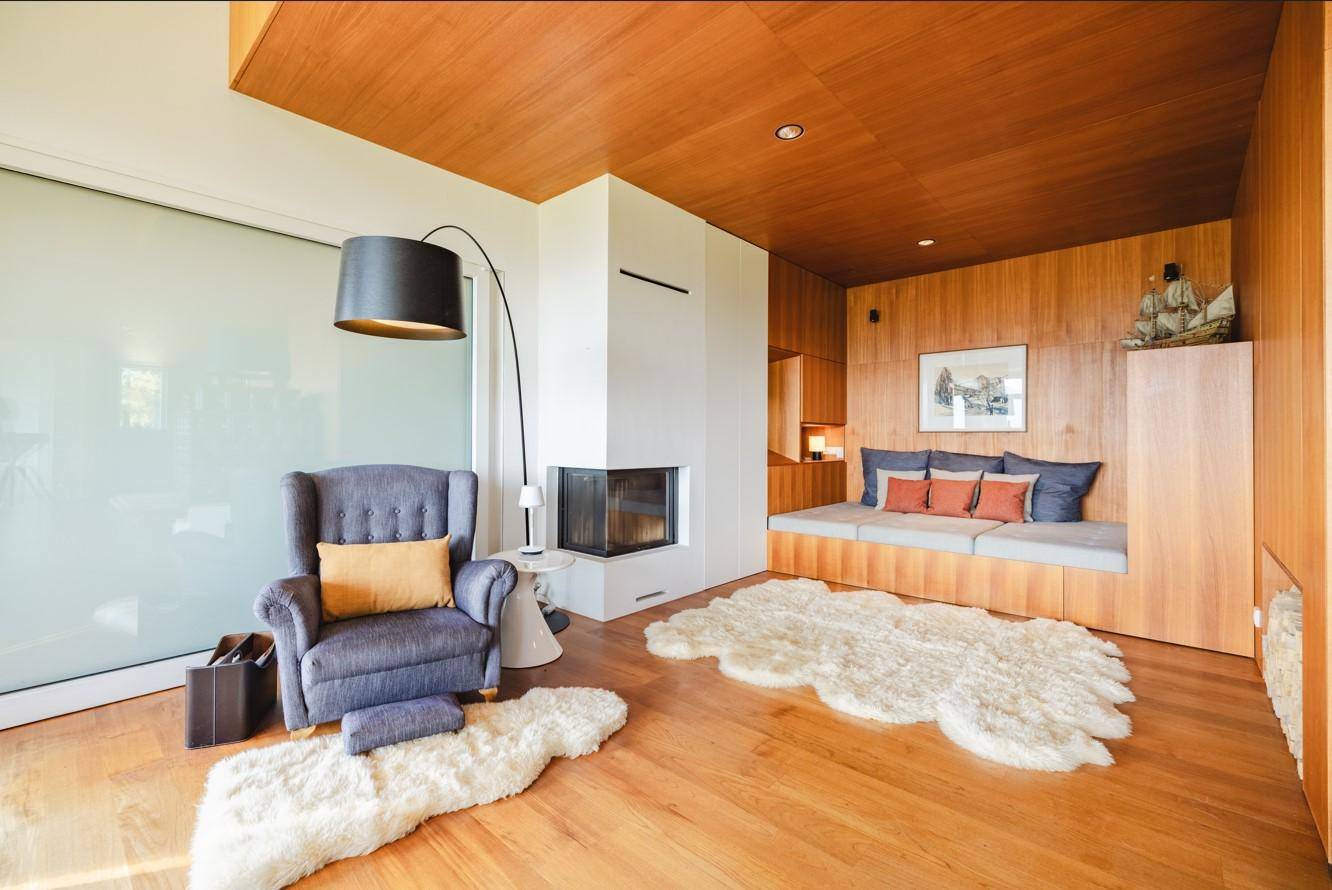 Gemütliche Wohnecke mit Kamin, Holzwänden und weichen Teppichen, ideal zum Entspannen.