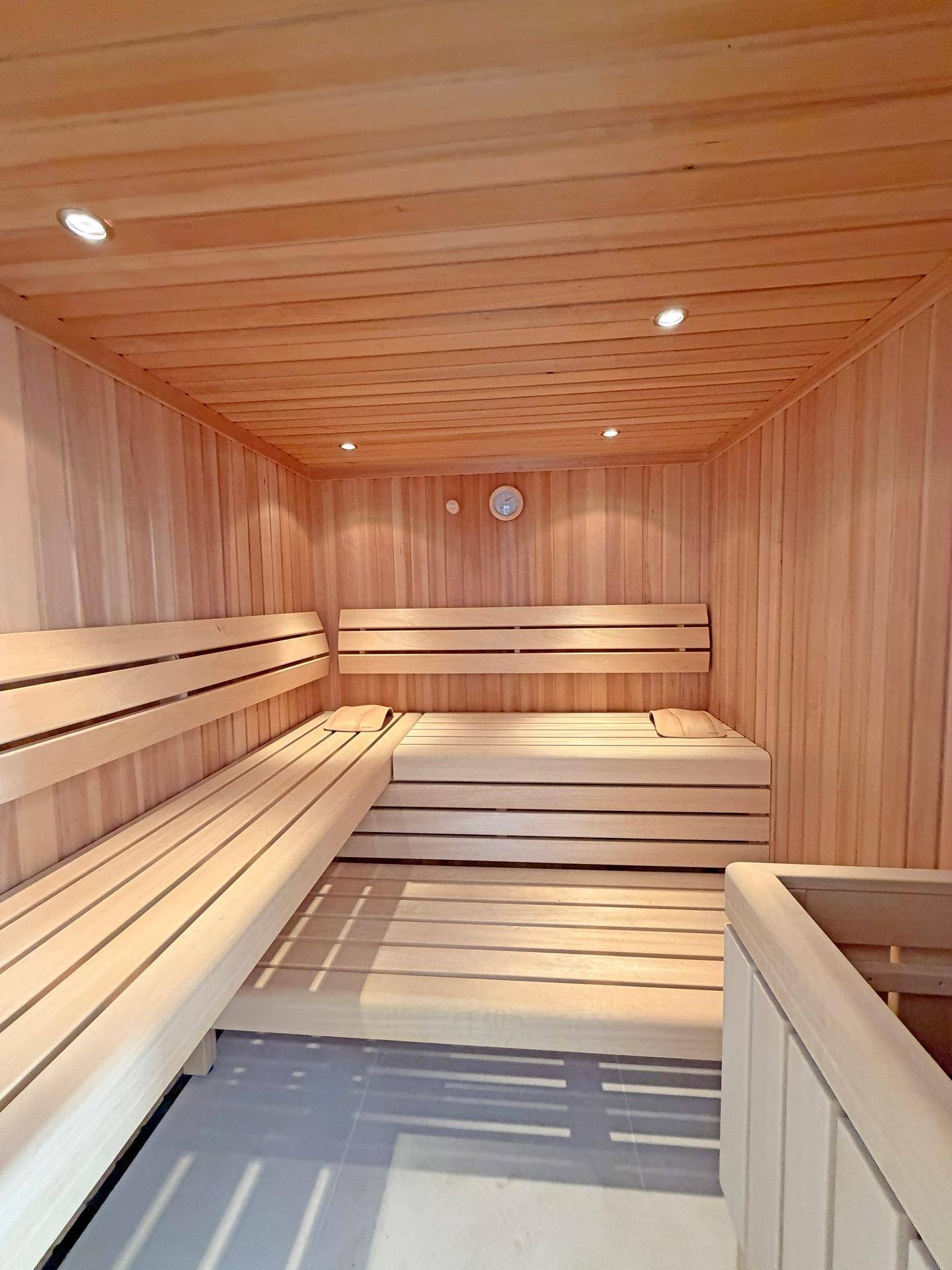 Helle Holzsauna mit mehreren Bänken für Entspannung und Wellness.
