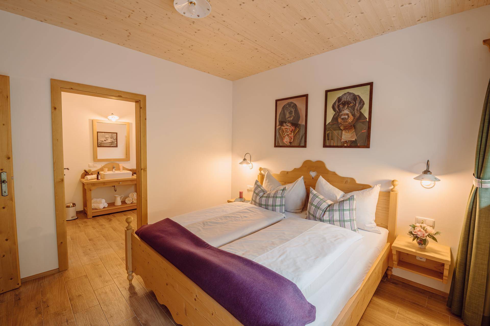 Gemütliches Schlafzimmer mit Holzbett und direktem Zugang zu einem angrenzenden Badezimmer.