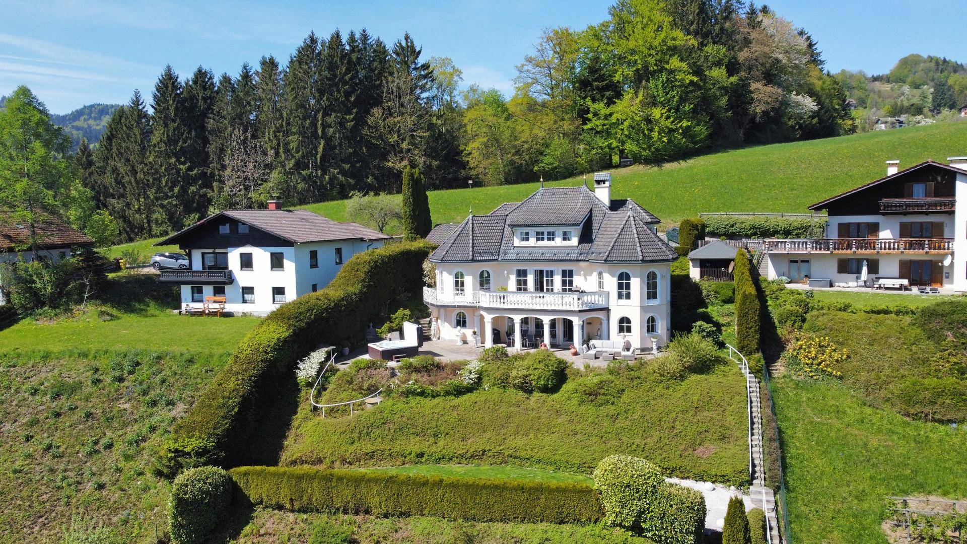 Panoramablick auf die Villa mit weitläufigem Garten und grüner Hügellandschaft.