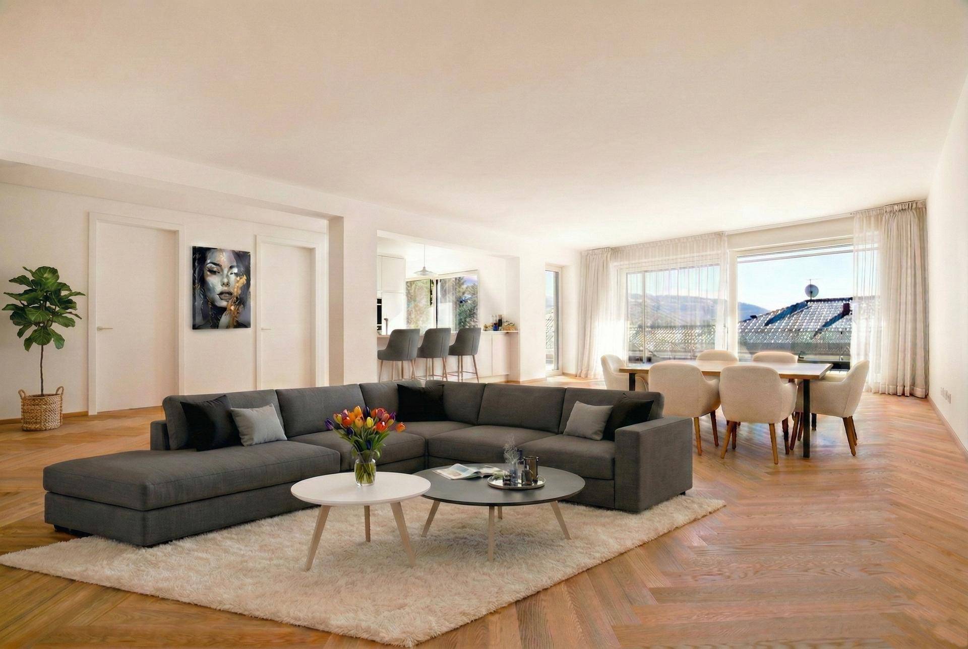 Heller, offener Wohn- und Essbereich mit modernem Sofa, Esstisch und hochwertigem Fischgrätparkett.