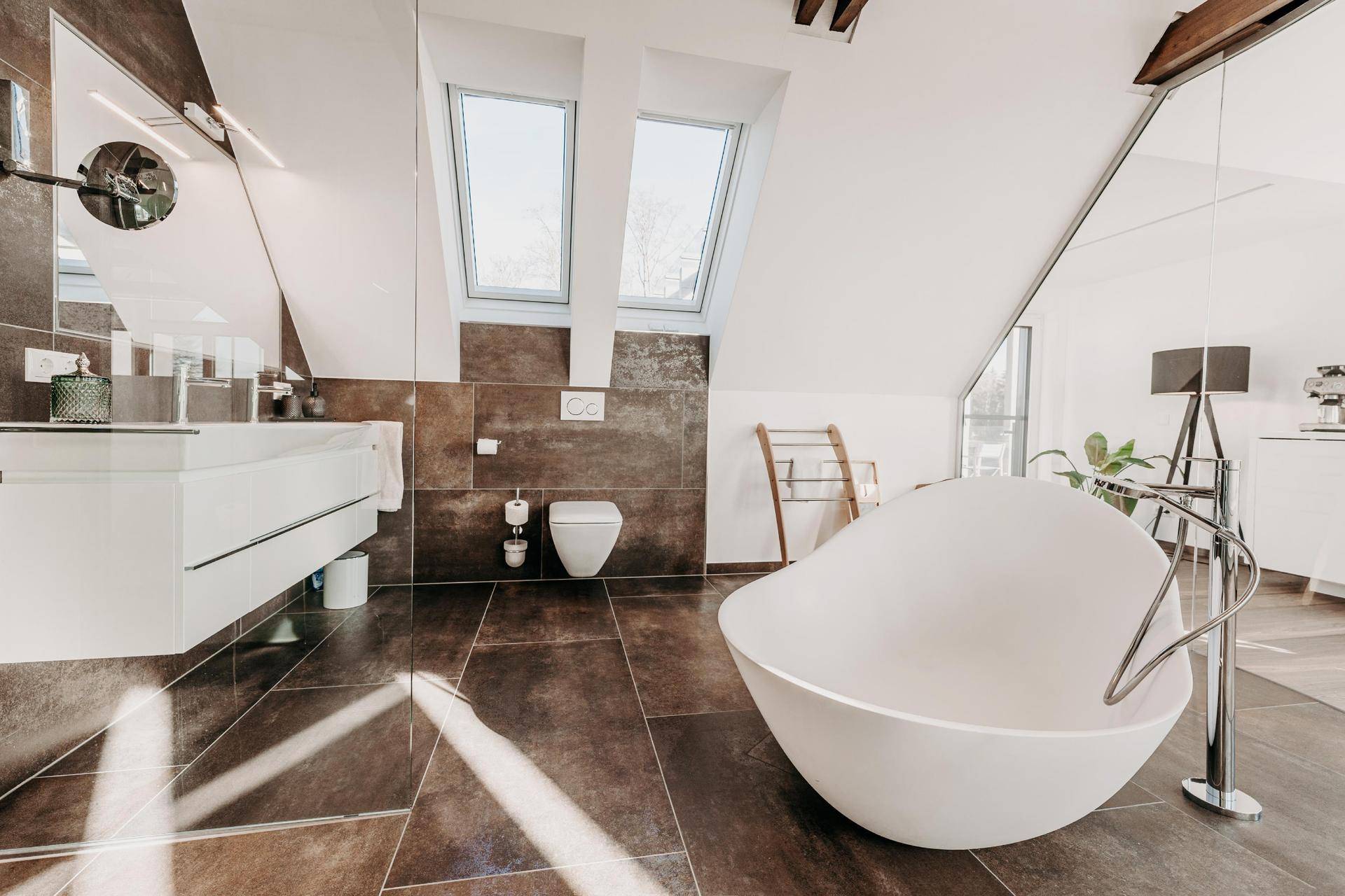 Modernes Badezimmer mit freistehender Badewanne, Doppelwaschbecken und Dachfenstern.