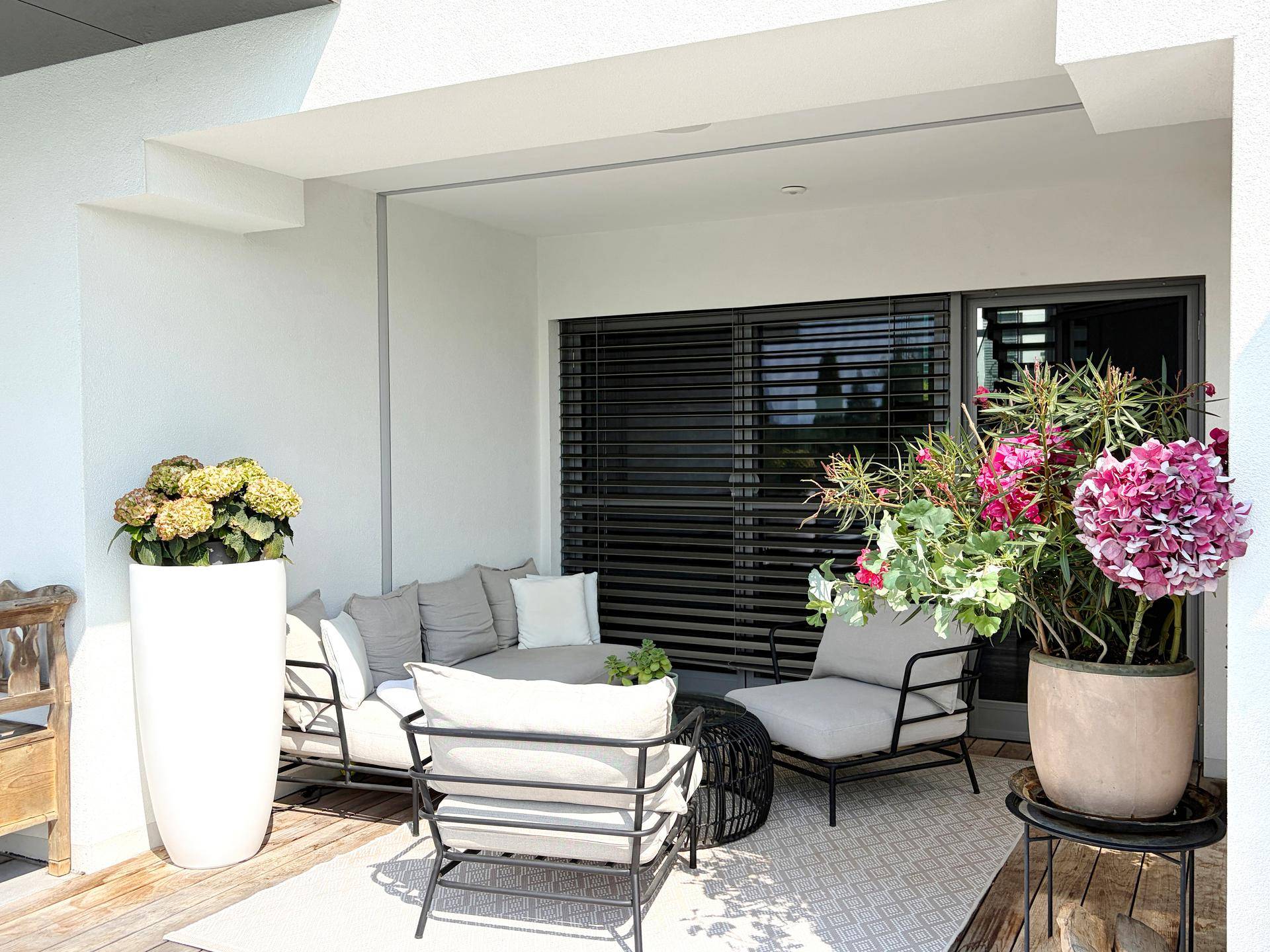 Gemütlicher Balkon mit modernen Loungemöbeln und vielen Pflanzen für entspannte Stunden.