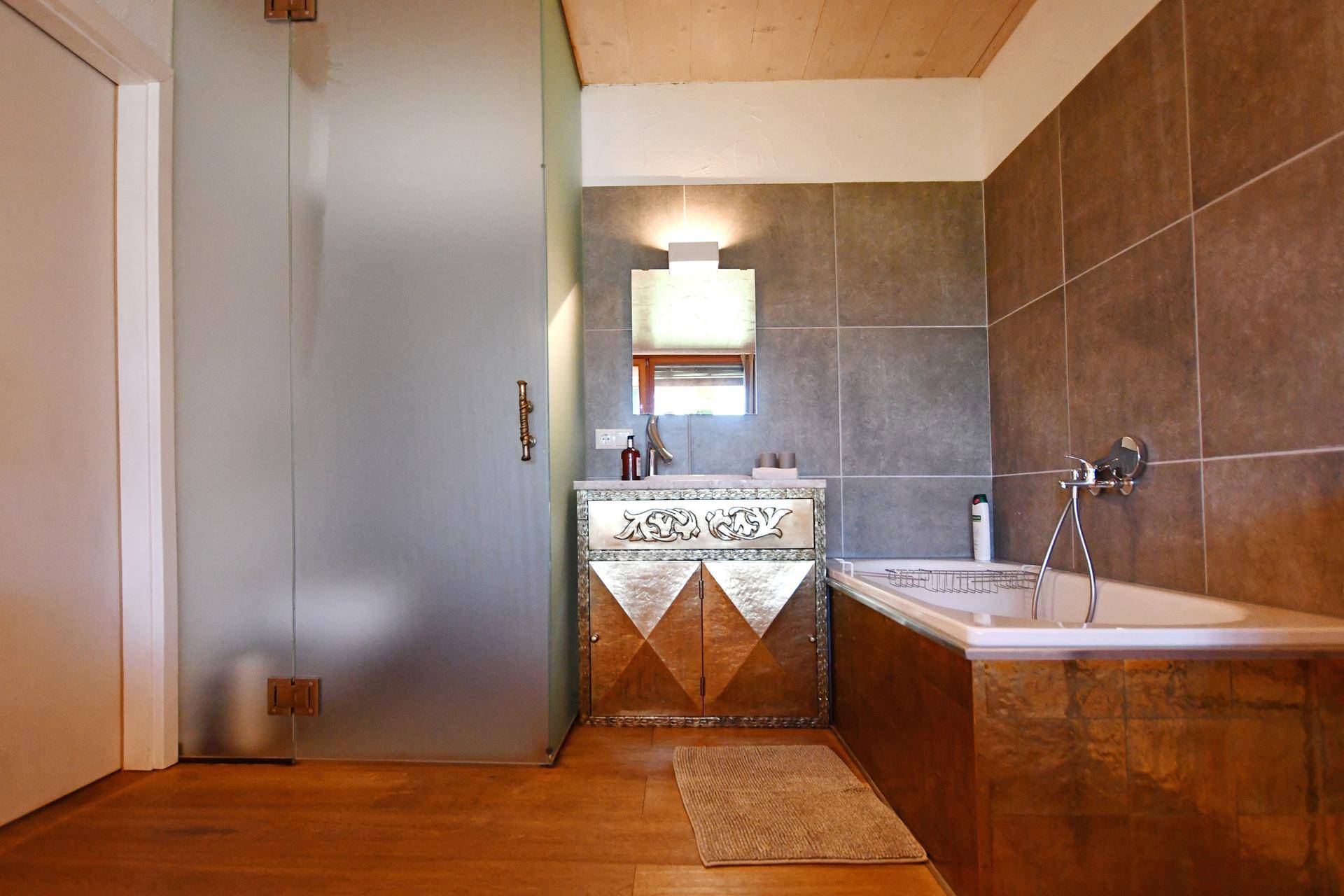 Modernes Badezimmer mit Badewanne, Duschkabine und stilvollem Waschtischunterschrank.