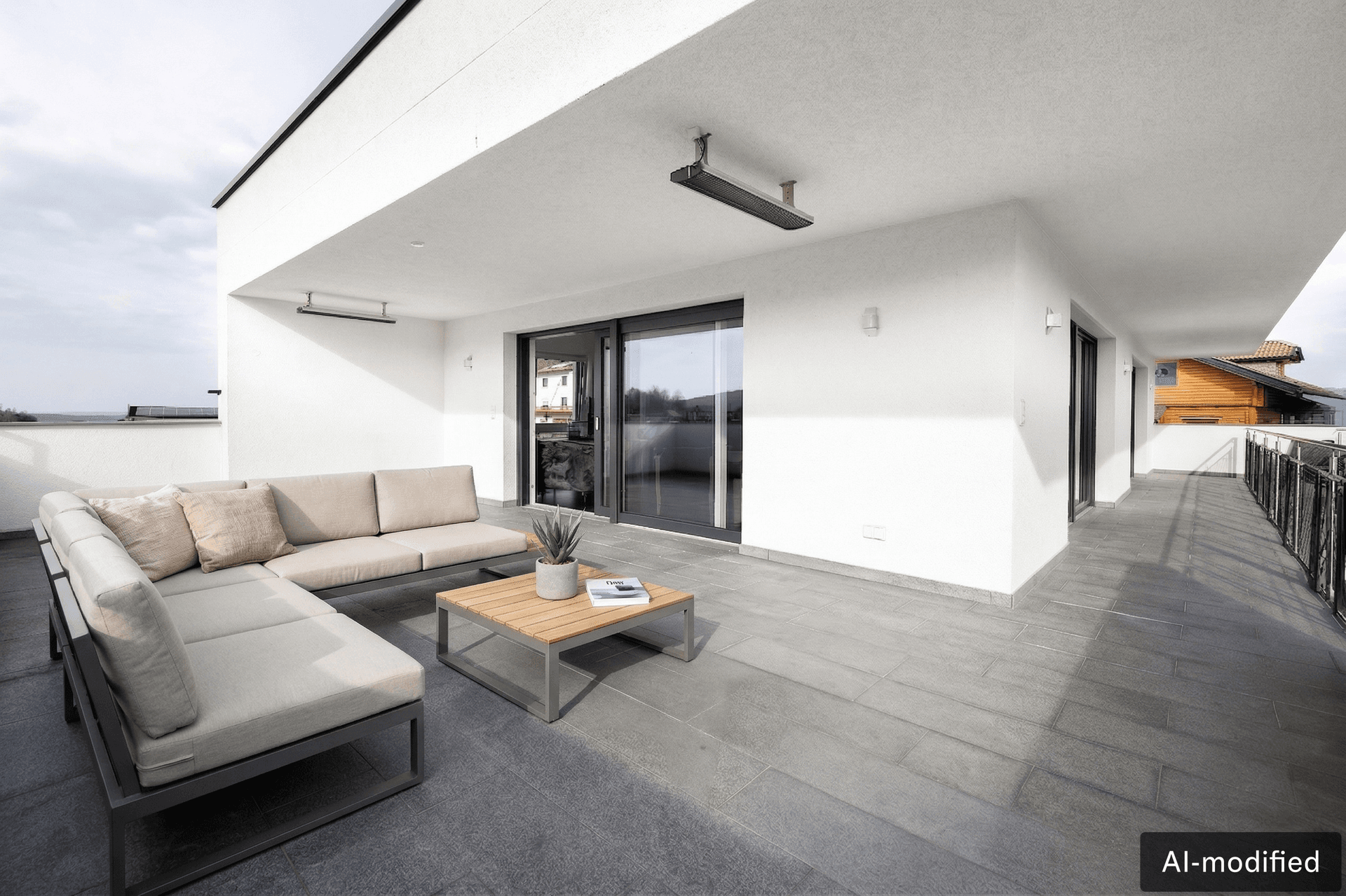 Geräumige Terrasse mit modernen Lounge-Möbeln, Fliesenboden und Blick auf die Umgebung.