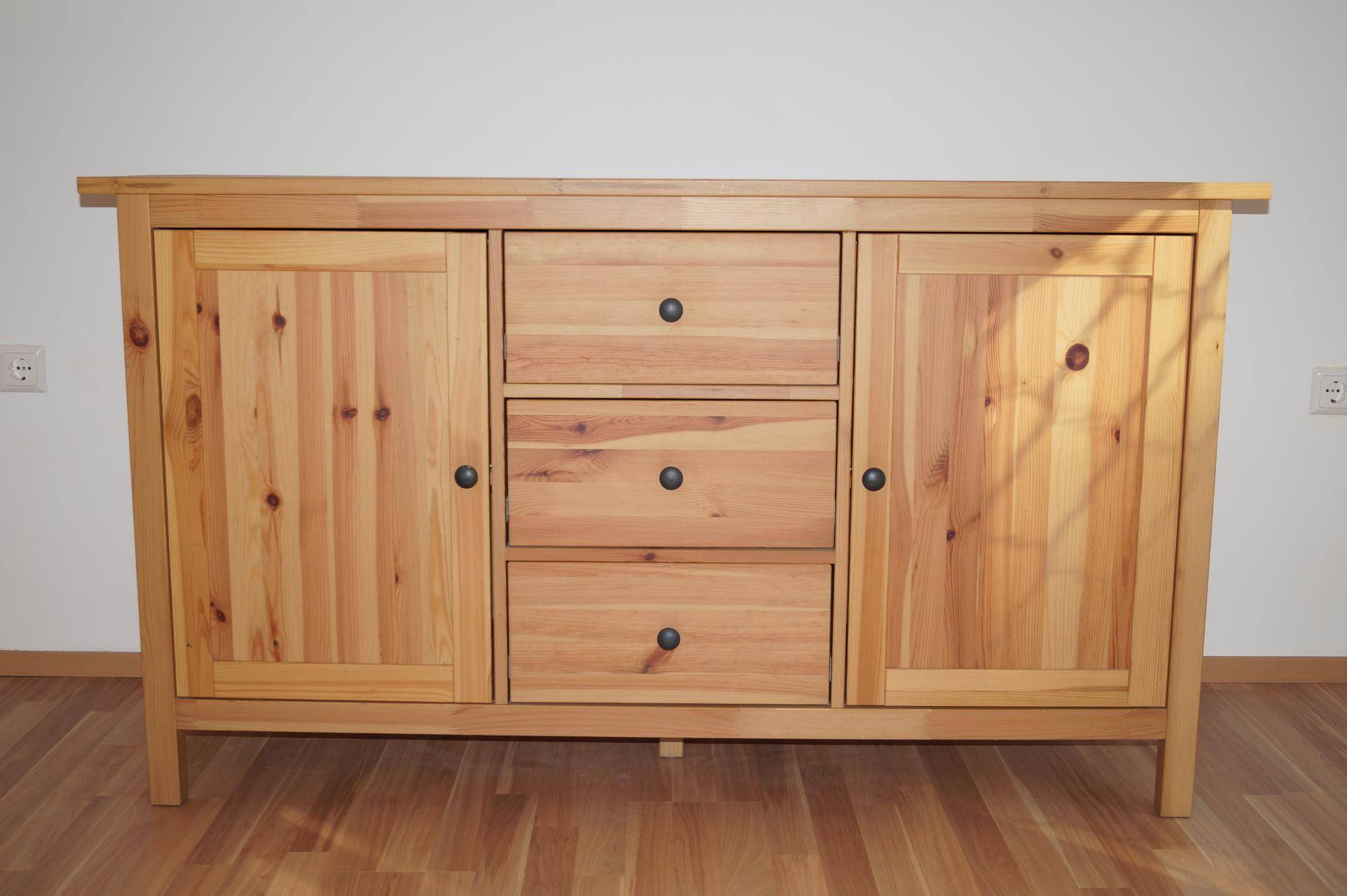 Rustikale Holzkommode mit Schubladen und Schranktüren, passend zum hellen Interieur.