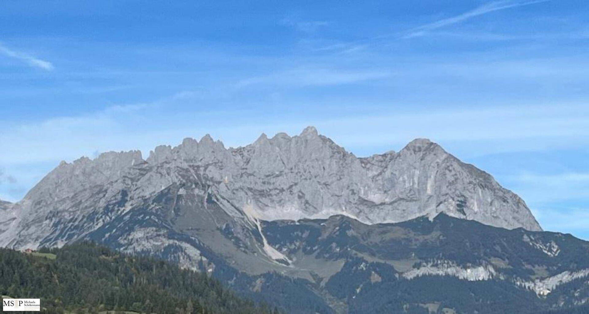 Panoramablick auf die majestätischen Berge des Wilden Kaisers unter einem klaren blauen Himmel.
