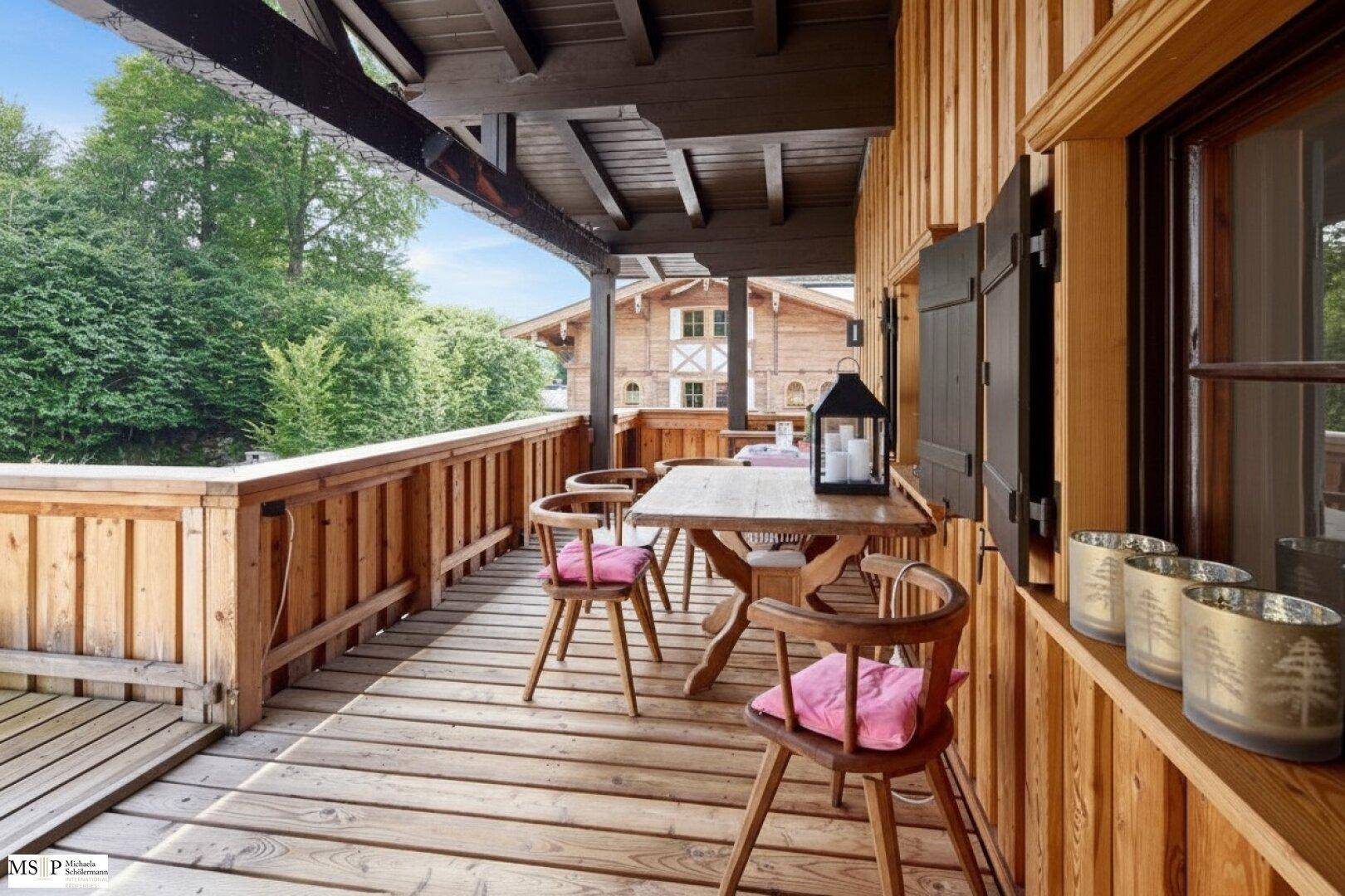 Großer überdachter Holzbalkon mit Esstisch und Stühlen, ideal für Mahlzeiten im Freien.