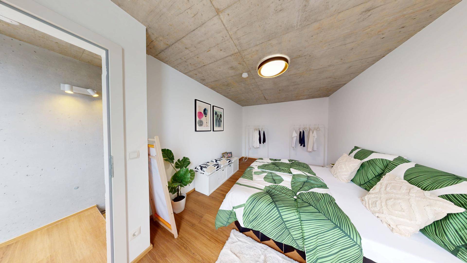 Modernes Schlafzimmer mit Holzboden, Doppelbett und schlichter Dekoration.