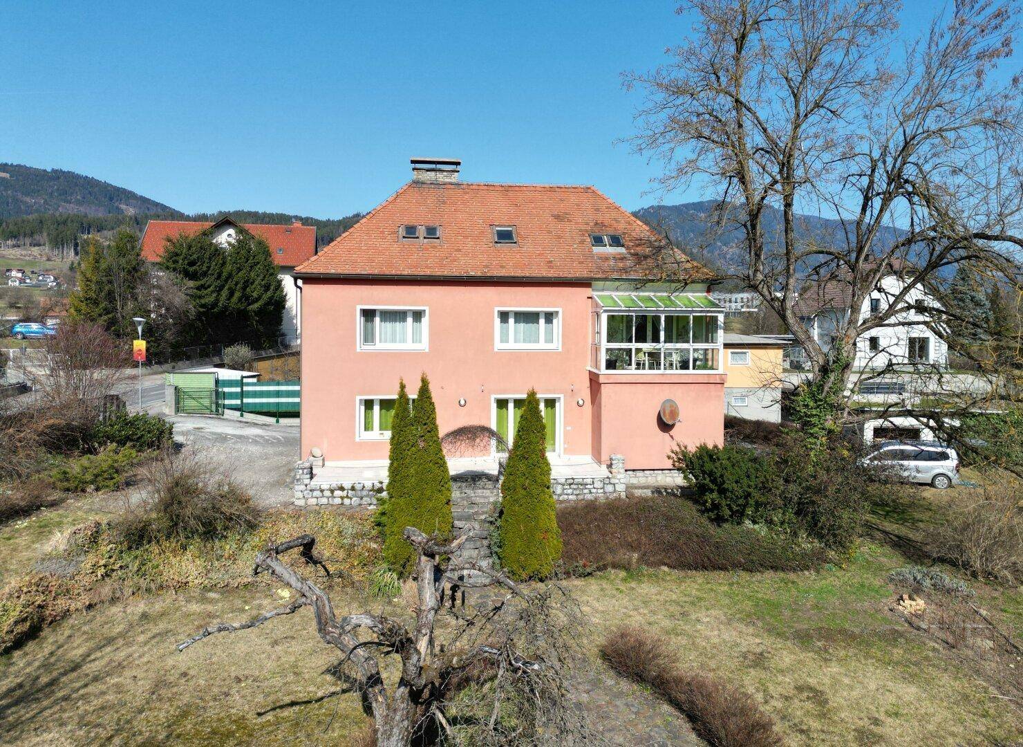 Ansicht des Hauses von vorne mit gepflegtem Garten und Bergblick.