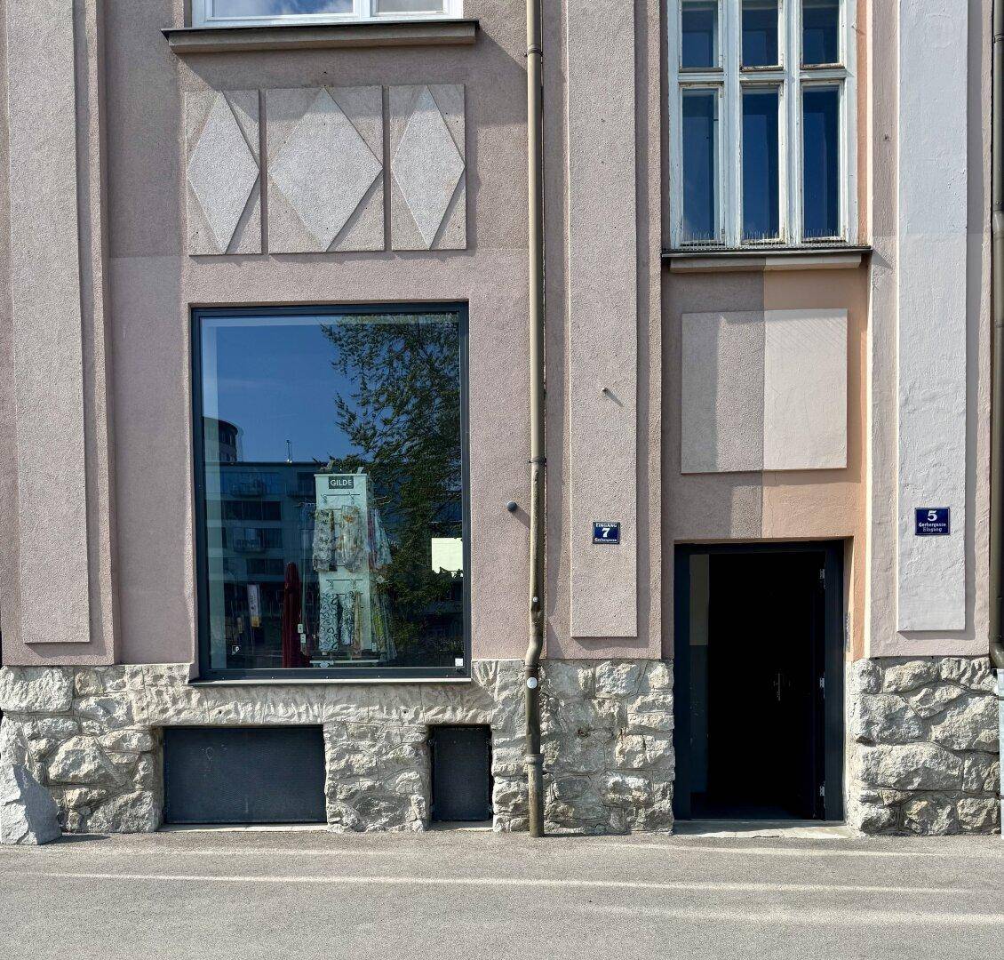 Detailansicht der Gebäudefassade mit einem großen Schaufenster und einem Eingangsbereich.