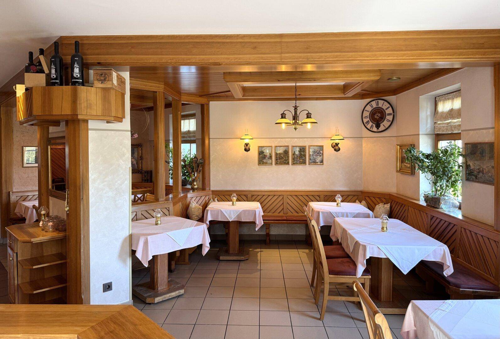 Großer Essbereich mit Holztischen, Bänken und Stühlen, traditionell eingerichtet mit Wanddekorationen.