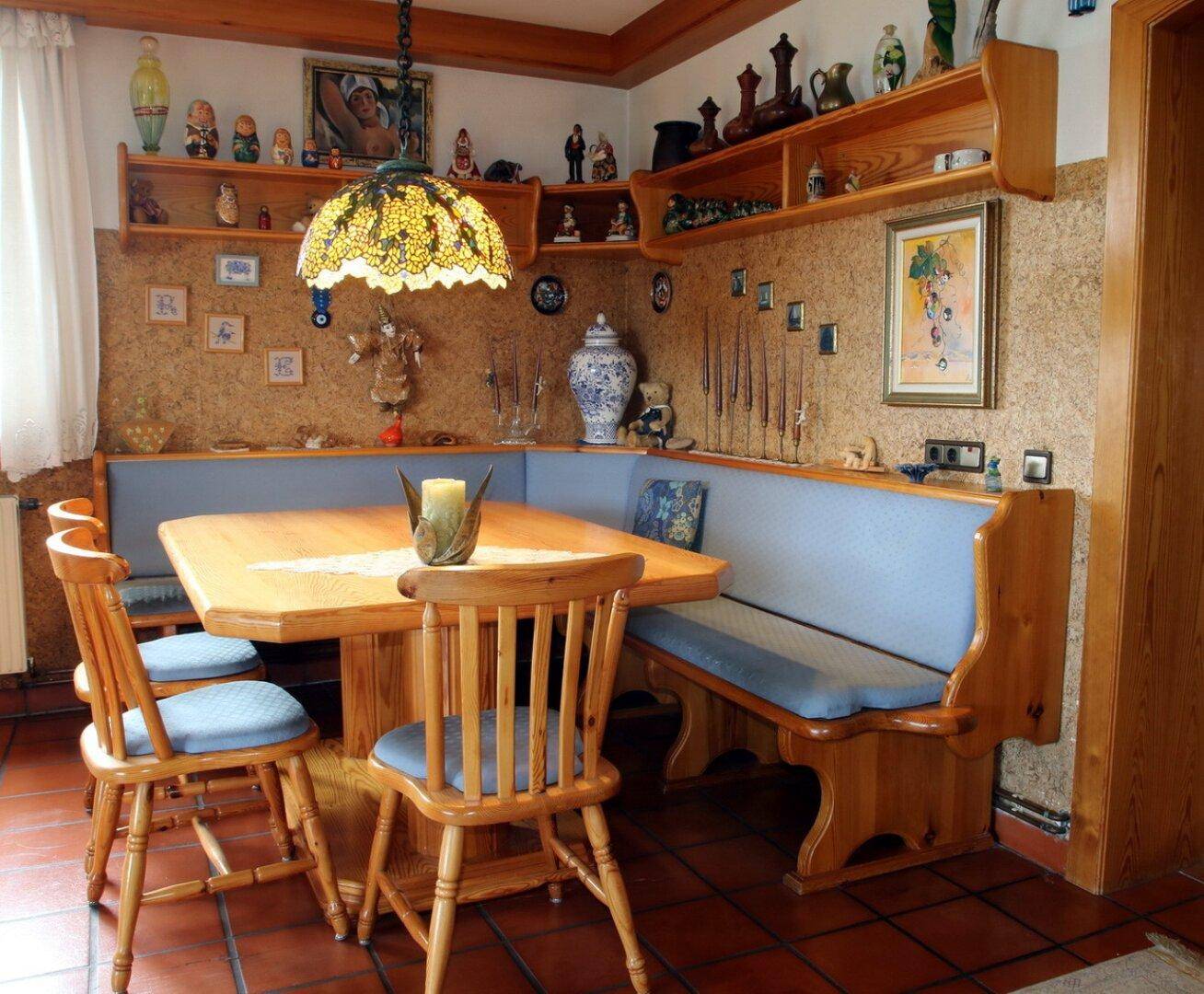 Traditionelle Essecke mit Holztisch, Eckbank und dekorativen Wandregalen.