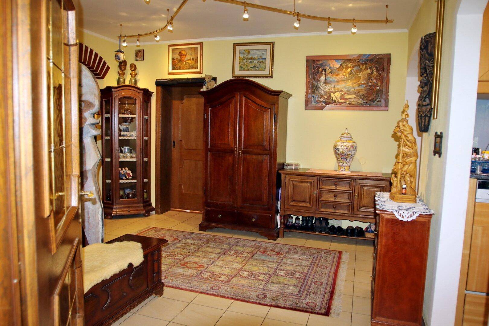 Geräumiger Flur mit traditionellen Holzmöbeln, Teppich und indirekter Beleuchtung.