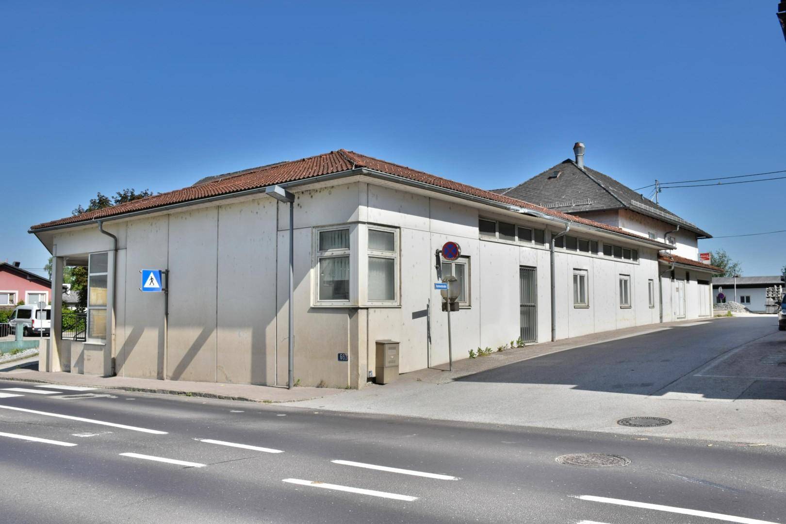 Seitenansicht des Geschäftsgebäudes mit mehreren Fenstern und der angrenzenden Straße bei Tageslicht.