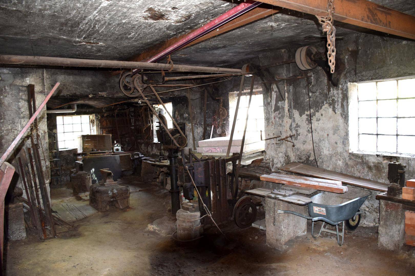 Historische Werkstatt mit alten Maschinen, rauen Wänden und industriellem Charme.