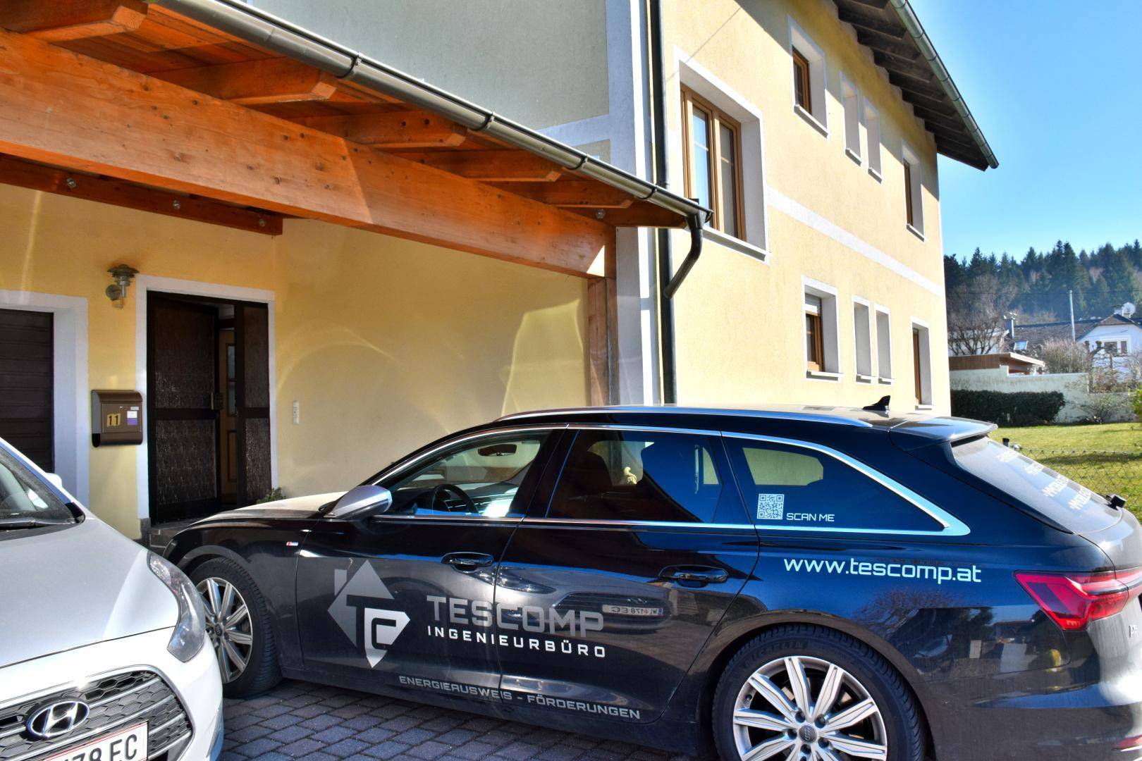 Eingangsbereich des Hauses mit gepflasterter Zufahrt und parkendem Fahrzeug.