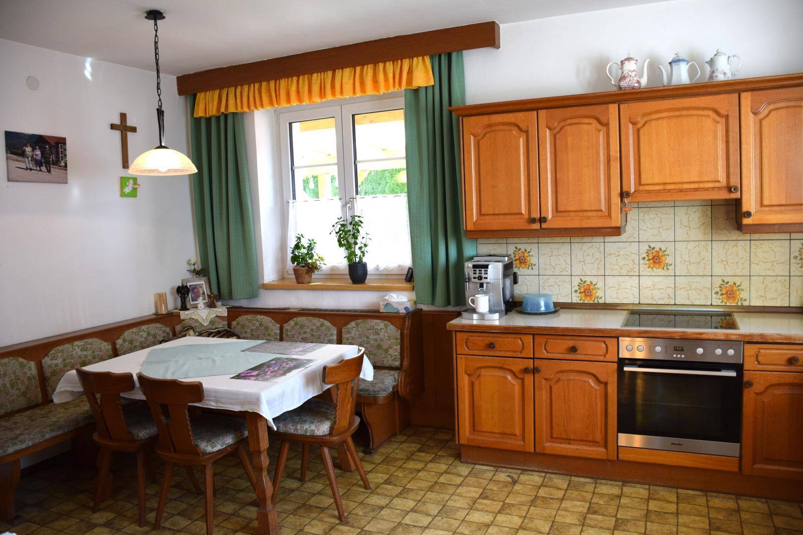 Traditionelle Küche mit Holzeinrichtung, gefliestem Spritzschutz und Eckbank.