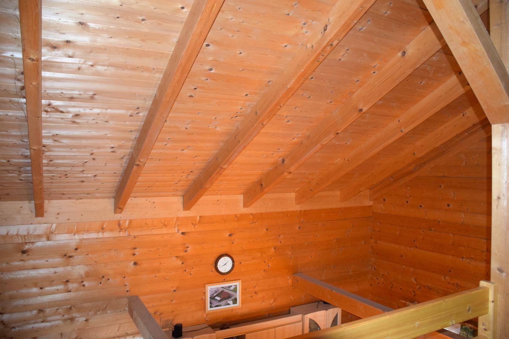 Sichtbare Holzkonstruktion des Daches und der Wände, die eine warme Atmosphäre schafft.