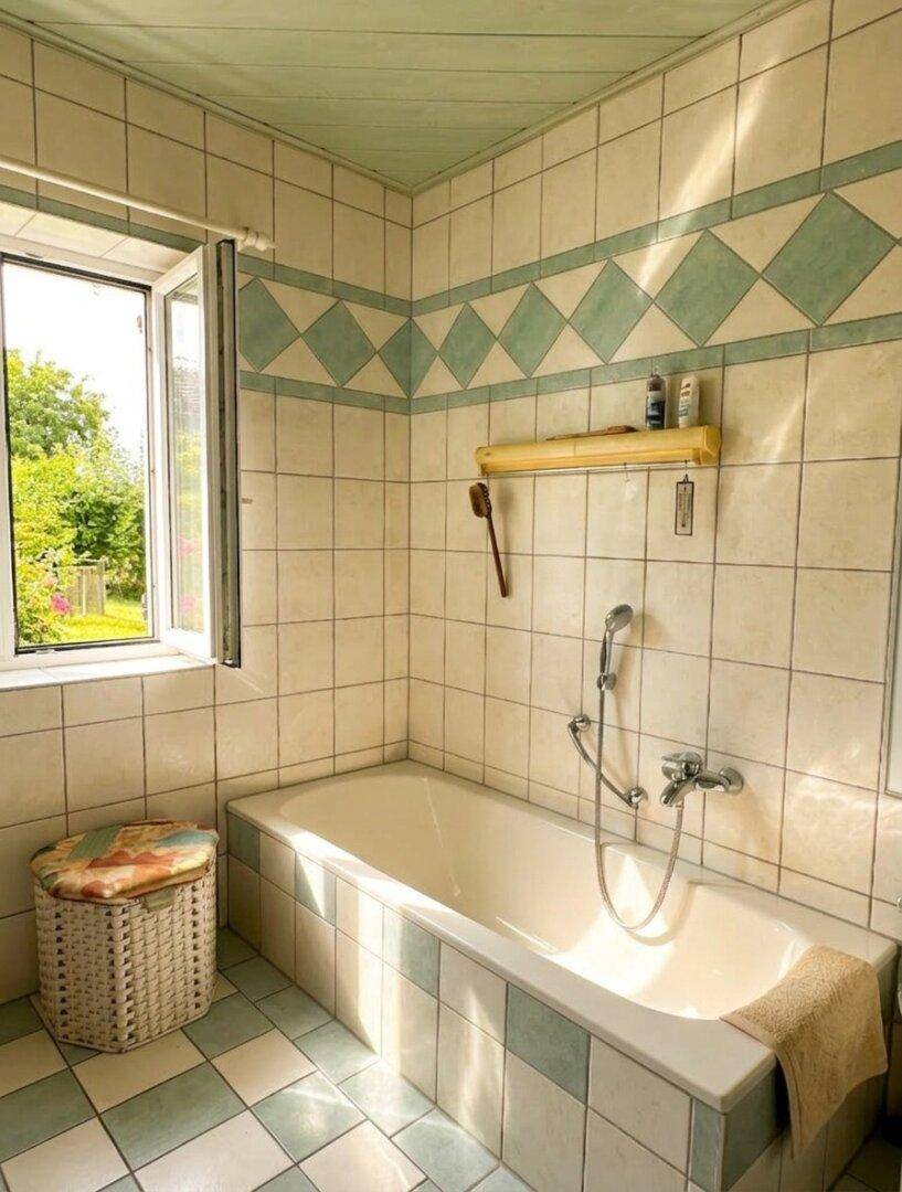 Badezimmer mit Badewanne, Fliesen und Fenster für natürliches Licht.