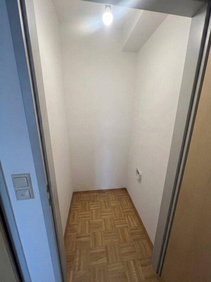 Kleiner Abstellraum mit Parkettboden und weißen Wänden, ideal für zusätzlichen Stauraum.