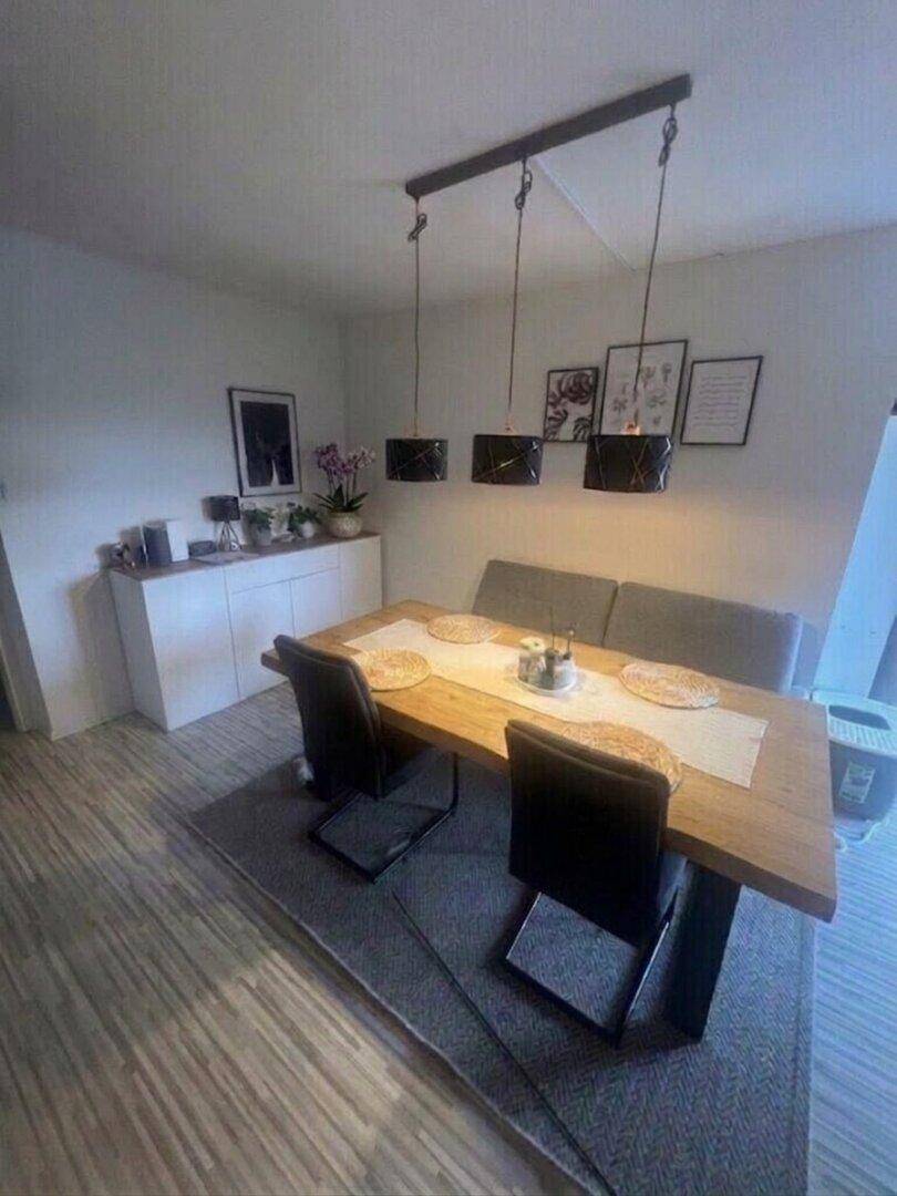 Gemütlicher Essbereich mit Holztisch, modernen Hängelampen und stilvoller Dekoration.