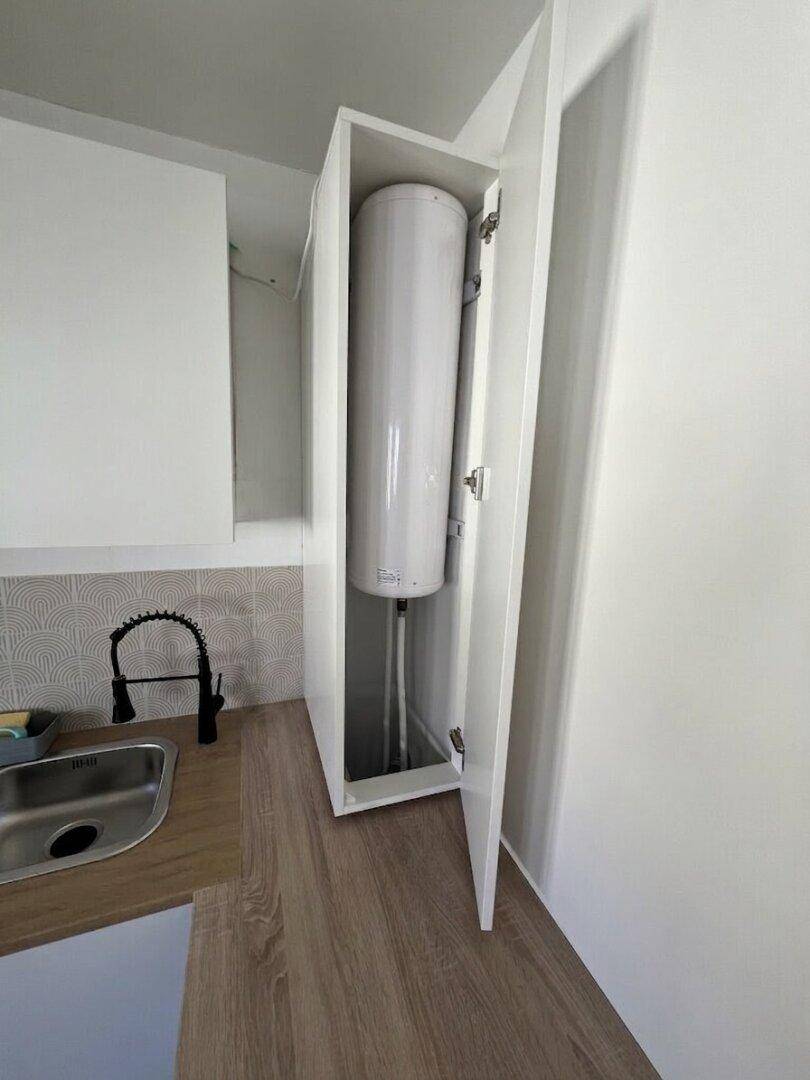 Versteckter Warmwasserspeicher in einem Schrank in der Küche.