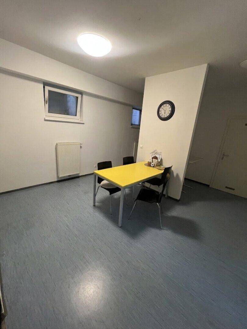 Essbereich mit einem auffälligen gelben Tisch und schwarzen Stühlen, ideal für Mahlzeiten.