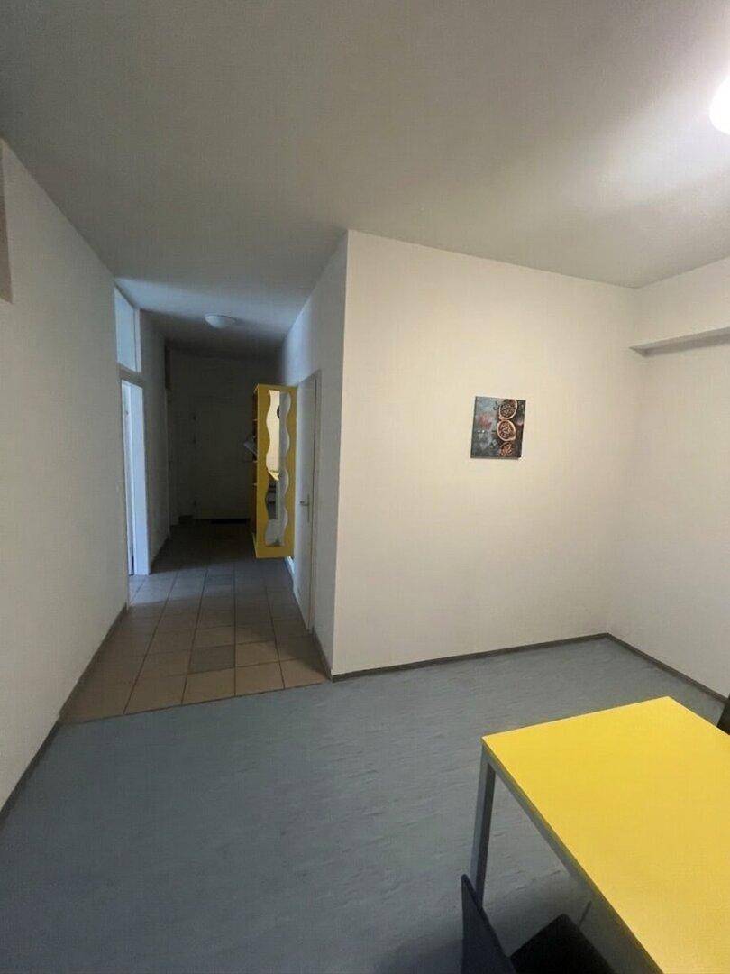Heller Flur mit Zugang zu verschiedenen Räumen, teilweise mit Vinylboden und Fliesen.