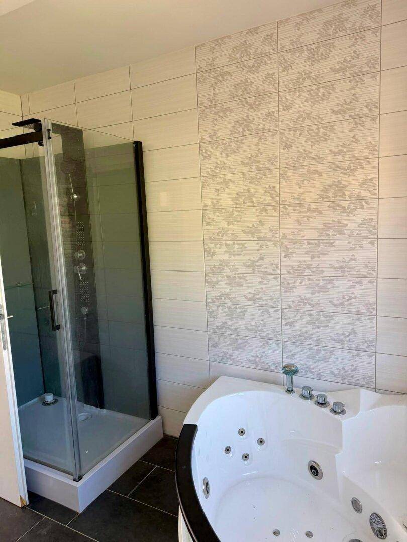 Modernes Badezimmer mit Duschkabine und einer luxuriösen Eck-Whirlpoolwanne.