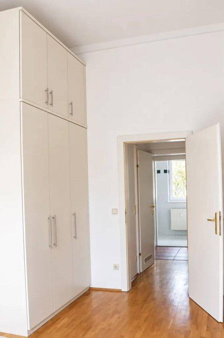 Schlafzimmer oder Flur mit großem Einbauschrank und Holzboden.
