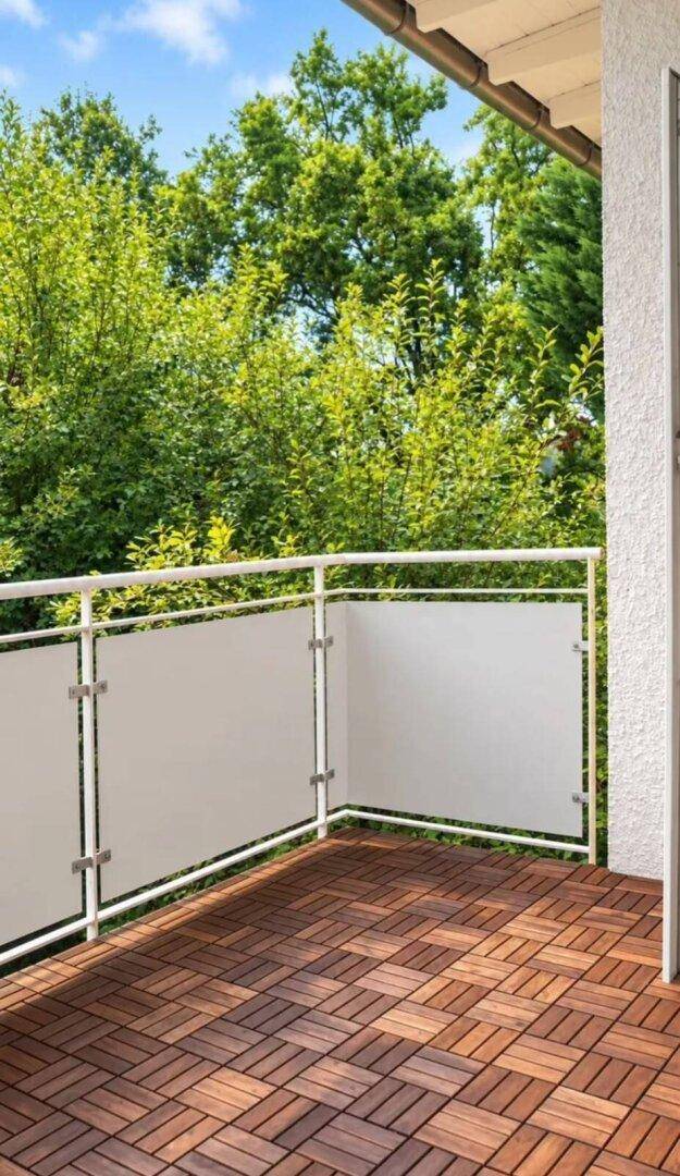 Balkon mit Holzdielenboden und moderner Brüstung, umgeben von viel Grün.