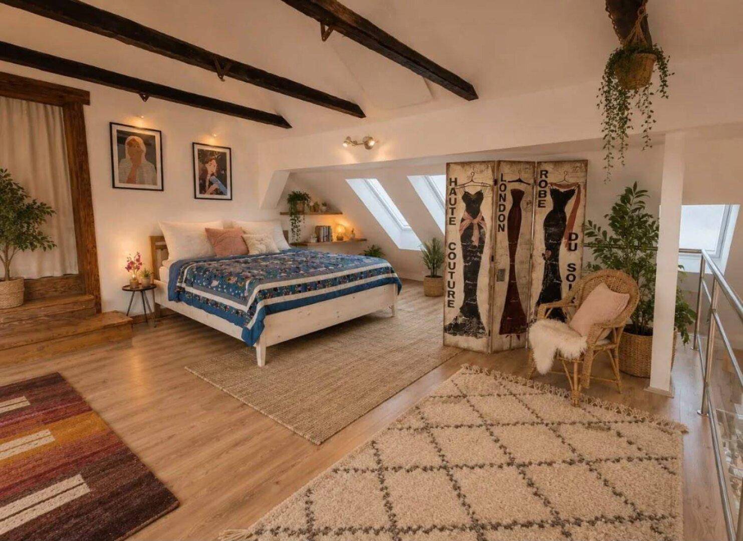 Geräumiges Schlafzimmer mit Holzbalken, Dachschrägen und gemütlicher Einrichtung.