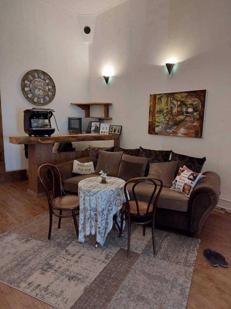 Gemütliches Wohnzimmer mit Sofa, Couchtisch und einer kleinen Bar, beleuchtet von Wandlampen.
